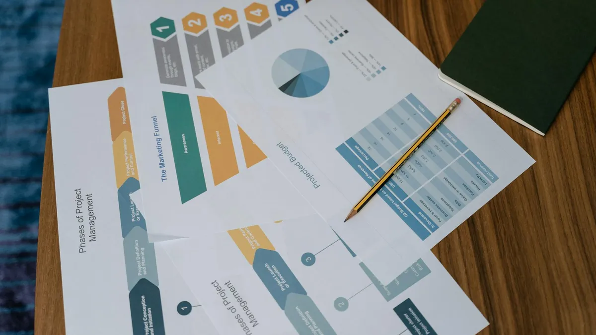 Vue aérienne de documents de gestion de projet et de graphiques sur un bureau avec un crayon