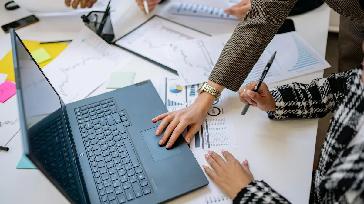 Business team analyzing data and charts during a meeting with a laptop on the table