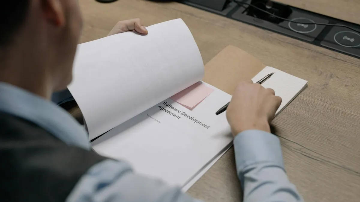 Professionnel analysant des options de logiciel de gestion commerciale à son bureau