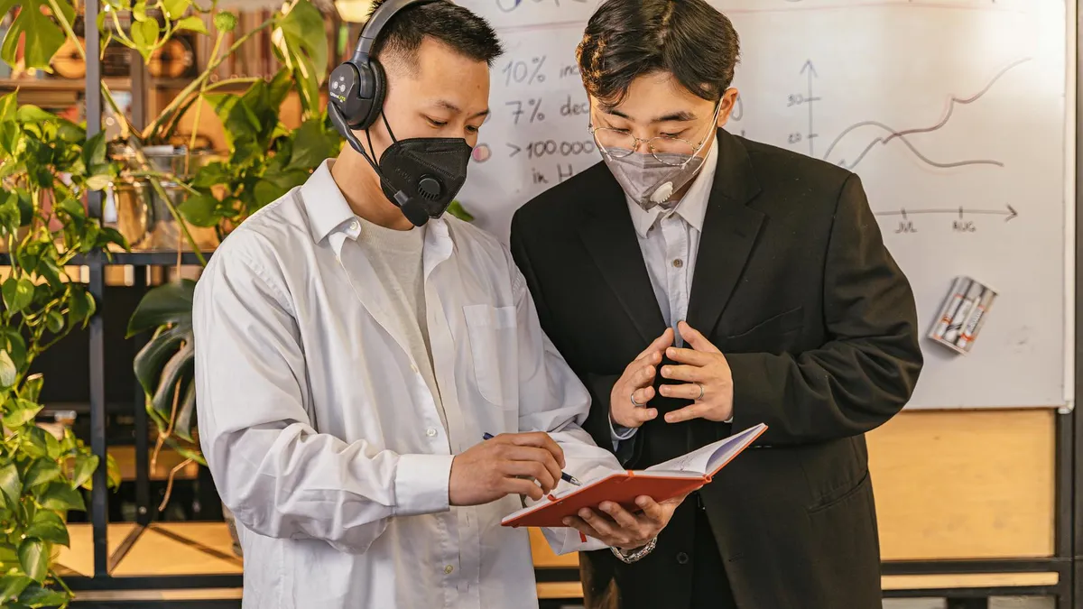 Dos profesionales revisando datos de ventas y estrategia comercial en una pizarra