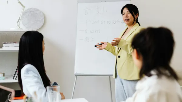 Responsable comercial formando a un nuevo miembro del equipo de ventas en una oficina moderna