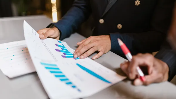 Des professionnels analysant des graphiques commerciaux lors d'une réunion d'équipe