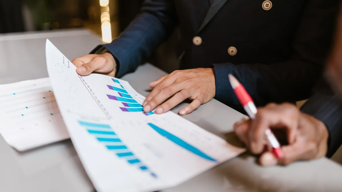 Des professionnels analysant des graphiques commerciaux lors d'une réunion d'équipe