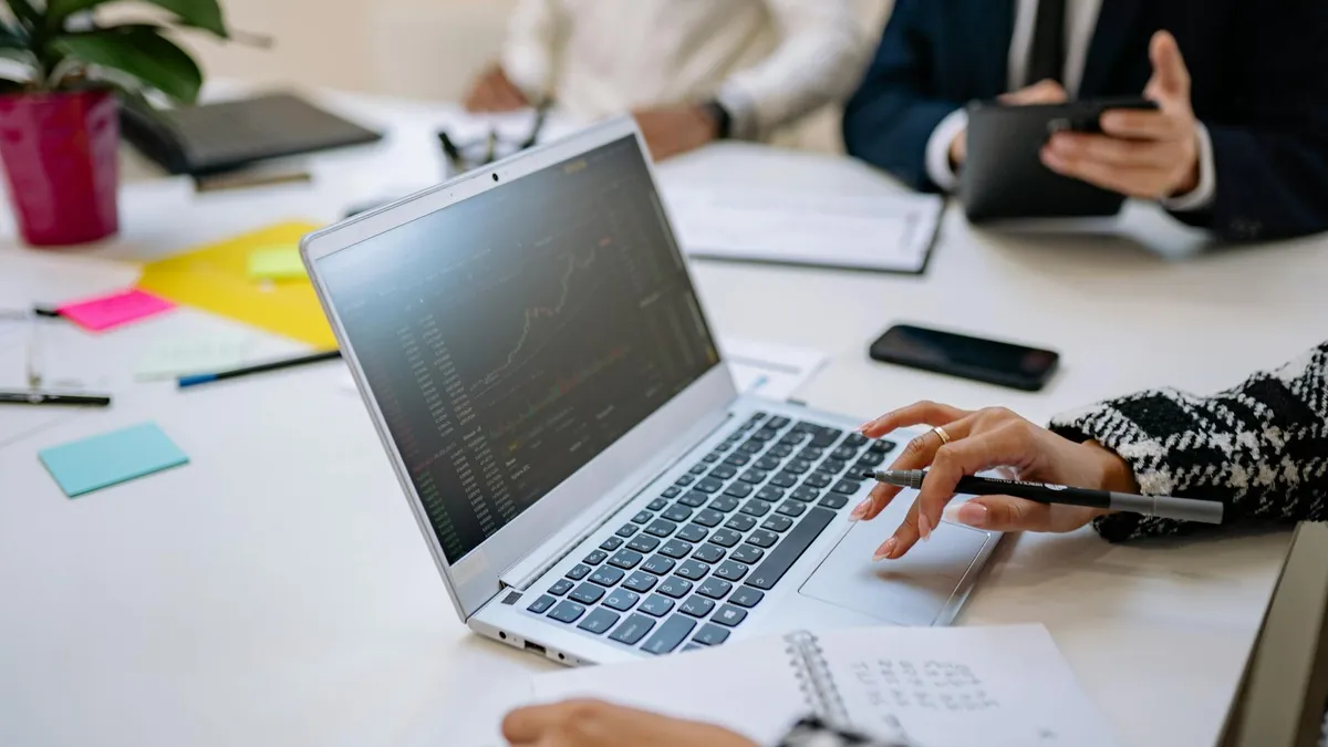 Profesionales analizando datos en un portátil durante una reunión de oficina